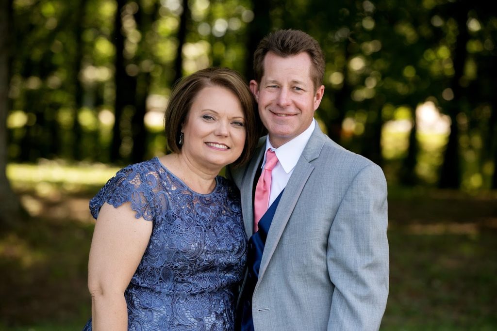 portrait of woman in blue lace dress and man in grey suit
