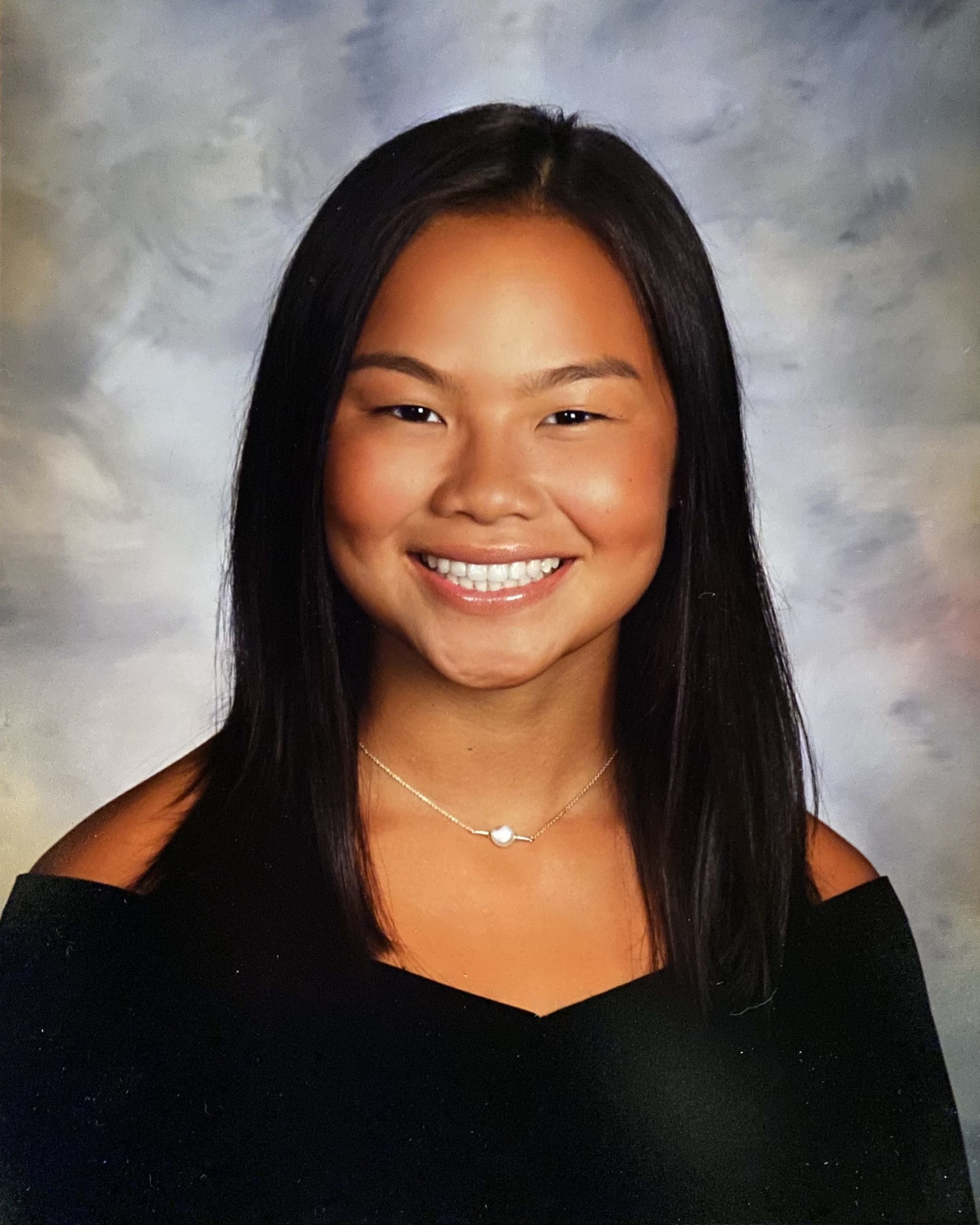 school photo of smiling girl in black off the shoulder top