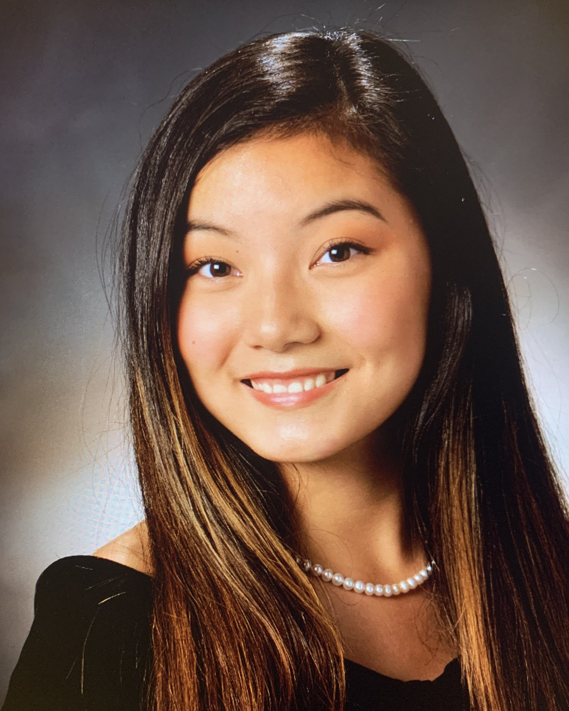 school photo of smiling girl in black off the shoulder top