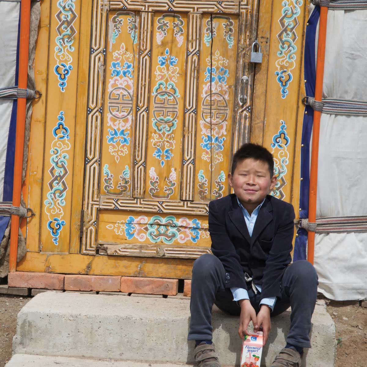 Boy sitting on step in Mongolia