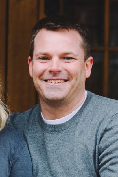smiling man in grey sweater