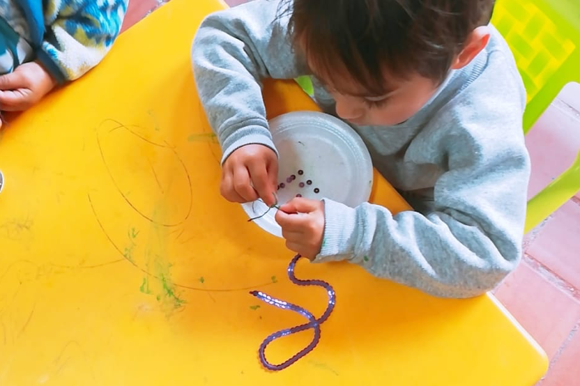 little child lacing yarn for a craft