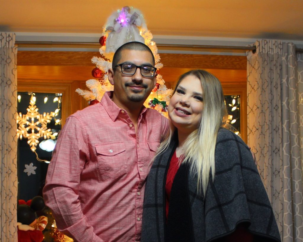man and woman standing in front of christmas