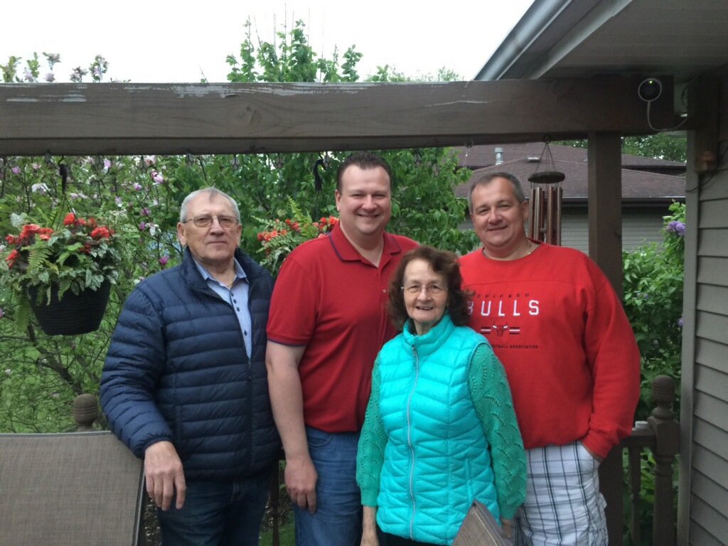 three men and one woman smiling at camera
