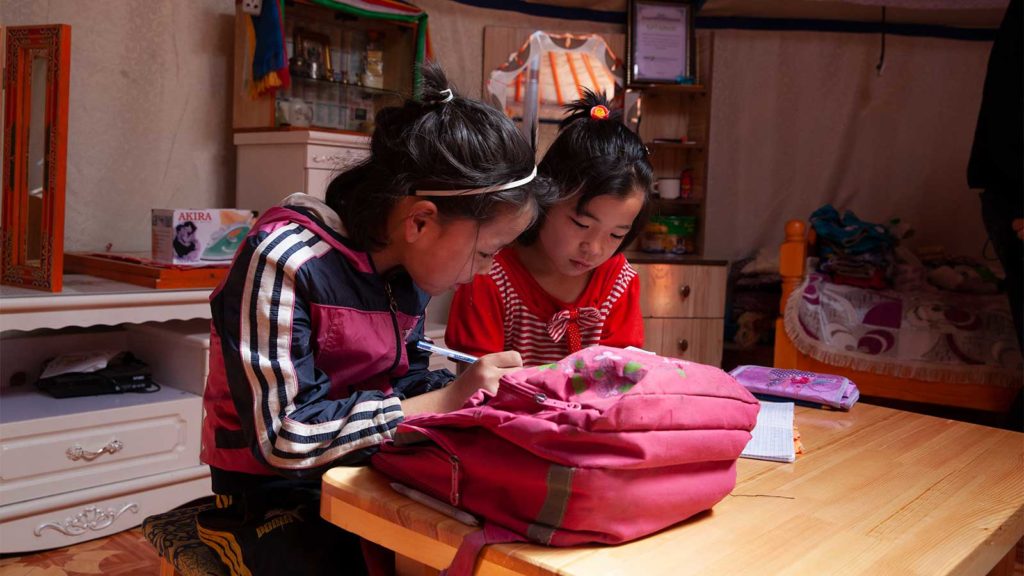 two girls writing in notebook