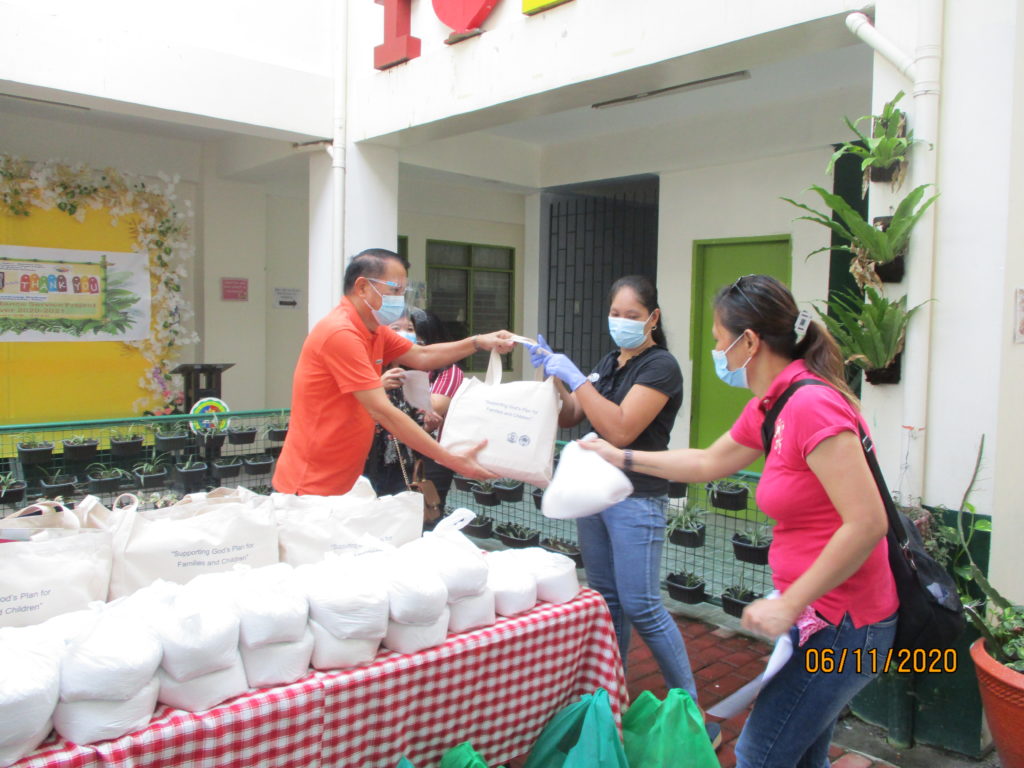 man handing out bags of supplies to families in need