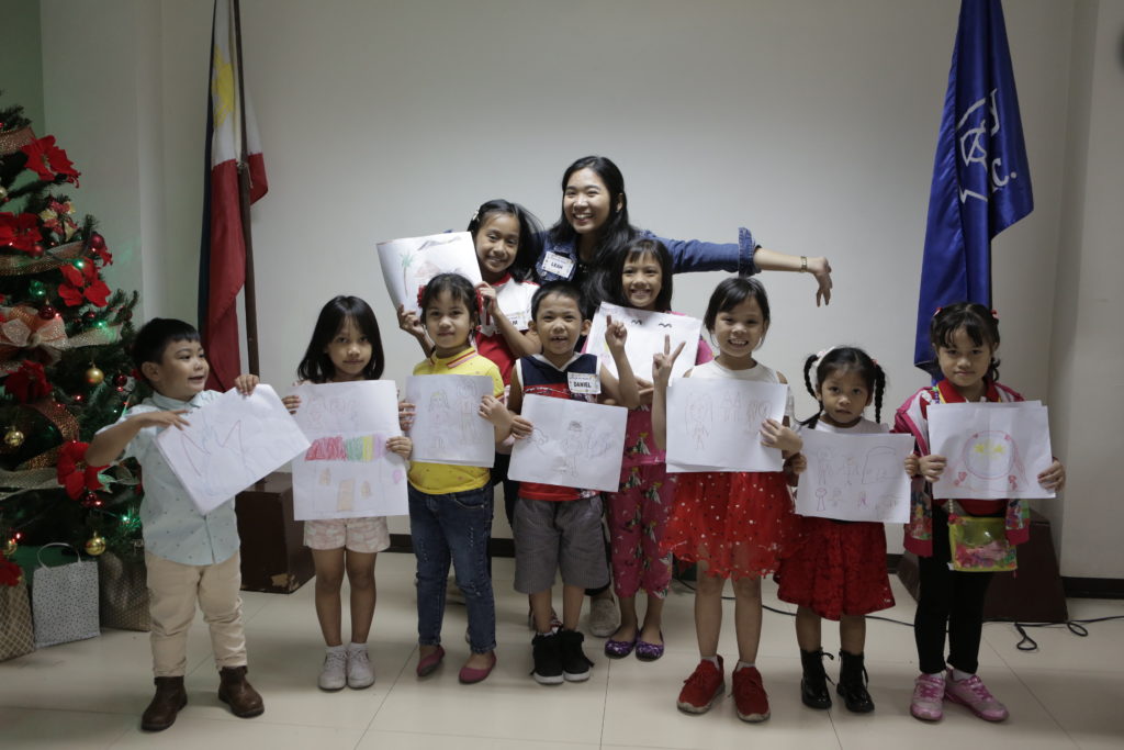 foster children lined up with handdrawn pictures smiling