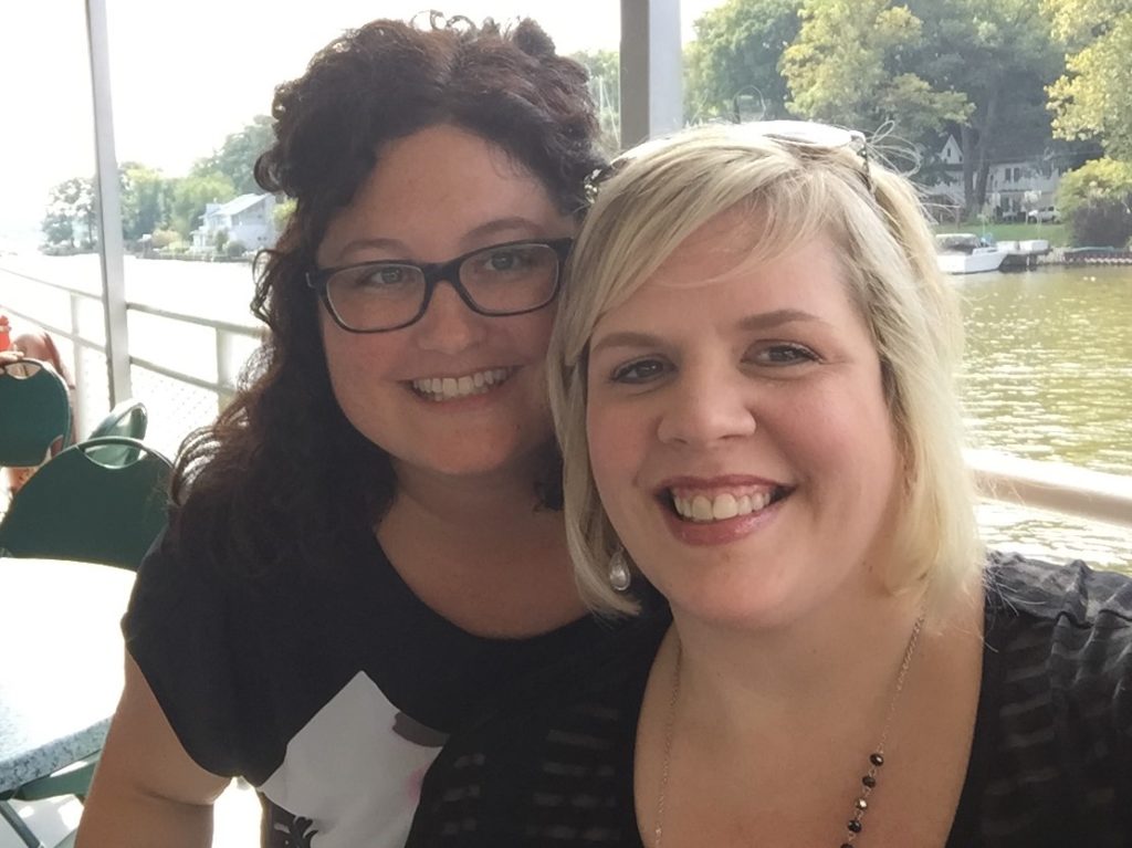 blonde and brunette smiling at camera for selfie