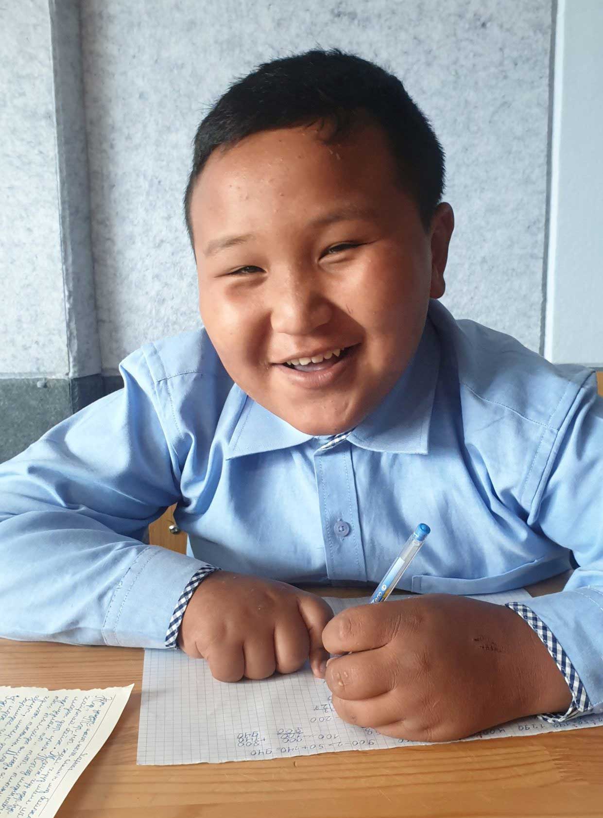 Mongolian boy writing in school