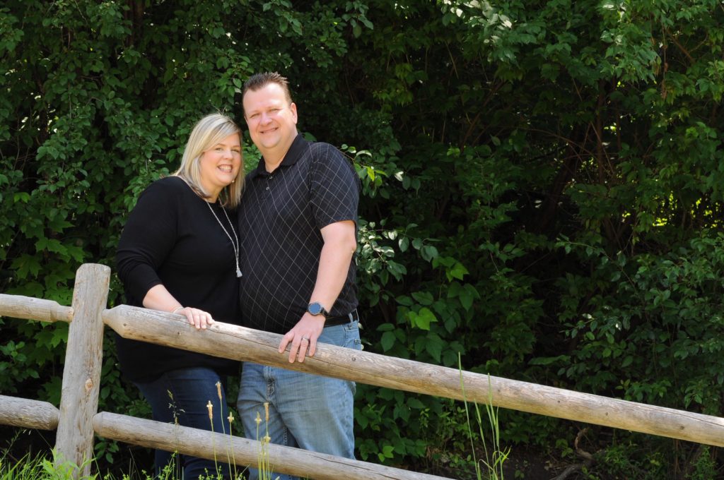 portrait of a man and woman at a fence