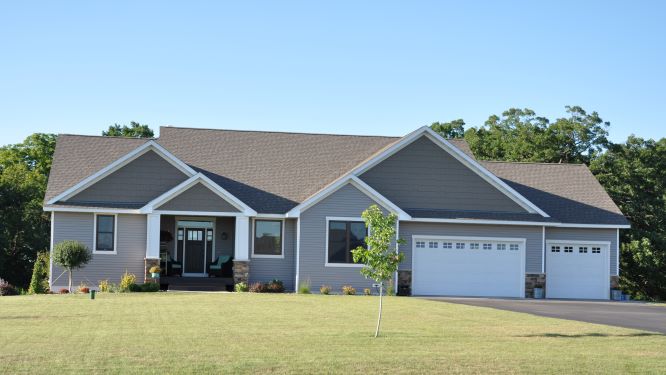 grey house with white trim and trimmed yard
