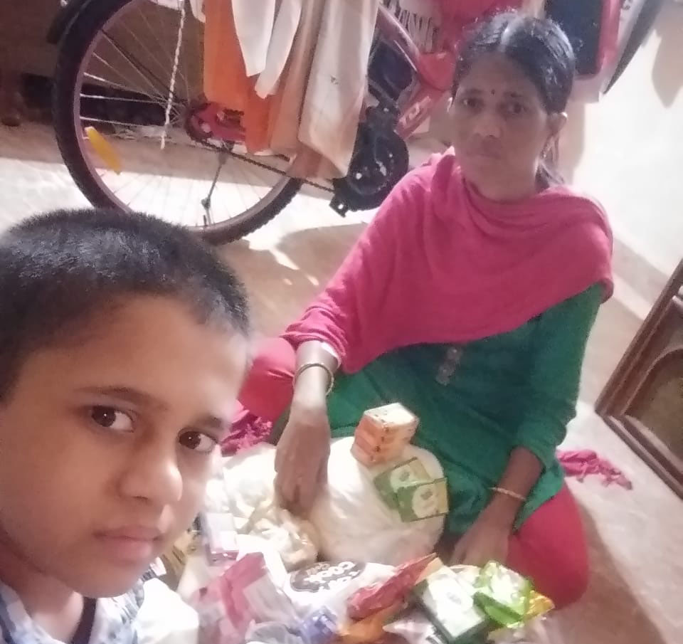 Women and son sitting on the ground with food