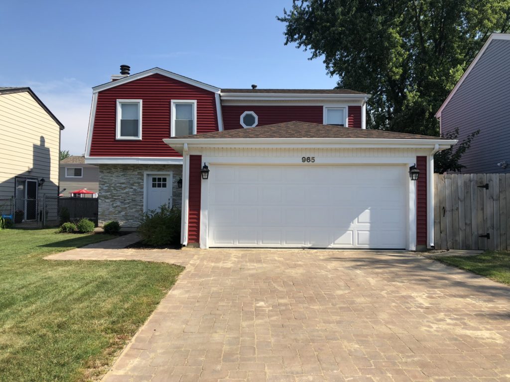 red two-story house with white trim and garage