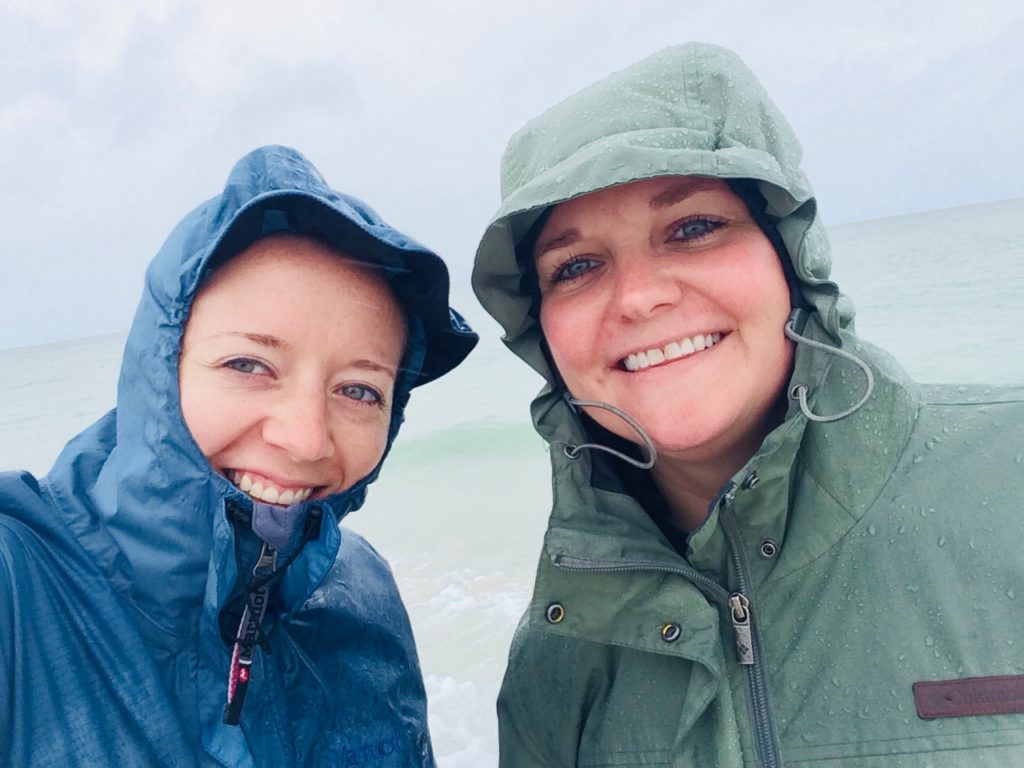 selfie of two women smiling in blue and green raincoats