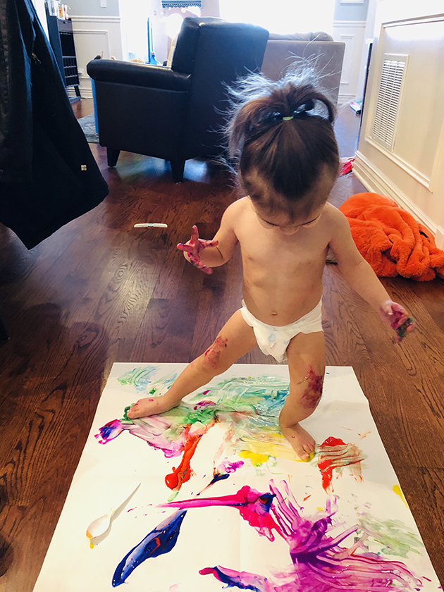 little girl in diaper finger painting