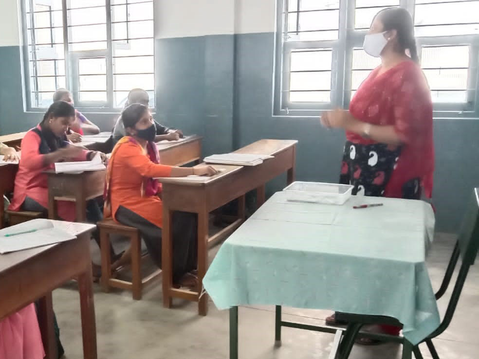 students sitting socially distanced with masks in classroom