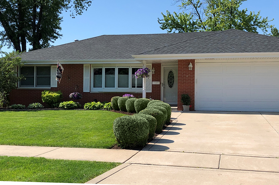 red brick house with white trim and green yard