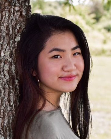 smiling girl leaning against tree