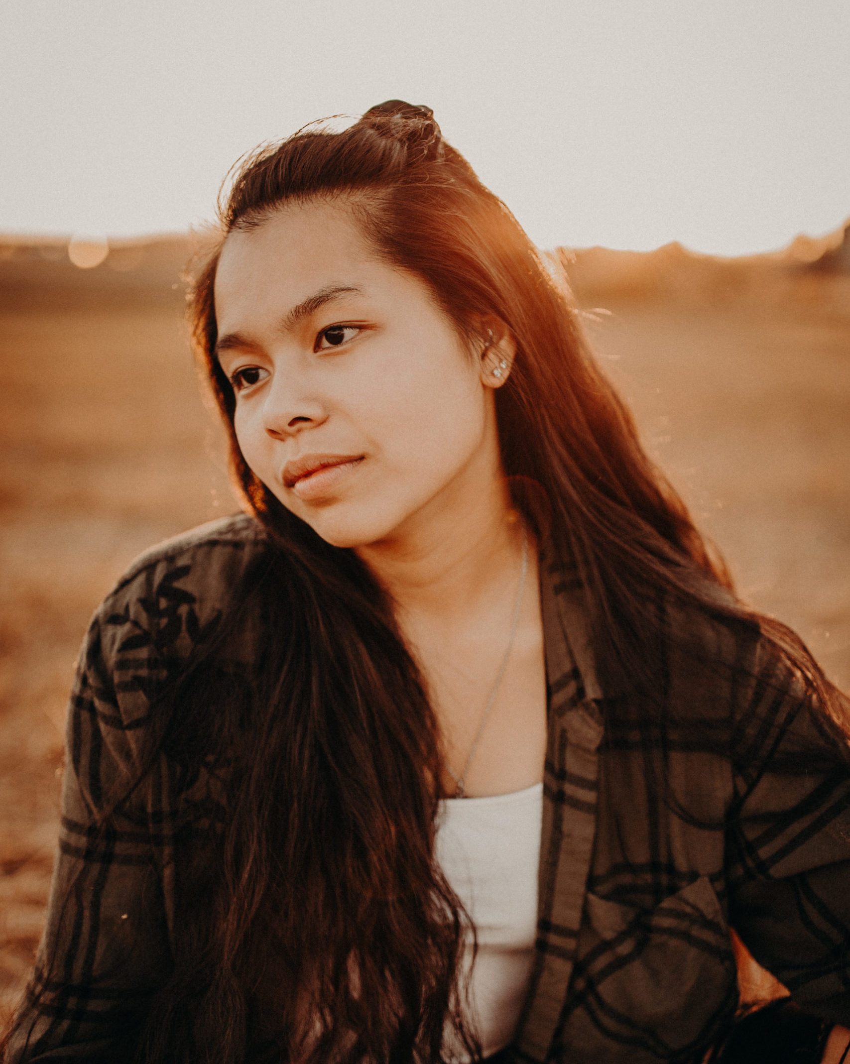 sepia tone photo of girl in sunlight looking into the distance