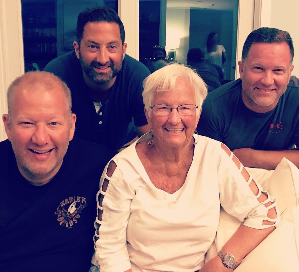 three men and one woman smiling