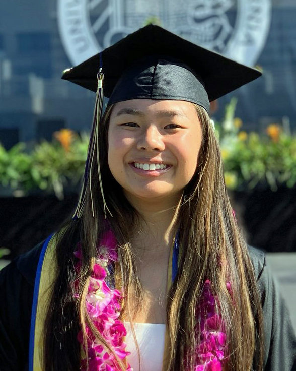 smiling girl wearing black graduation cap and gown wearing purple