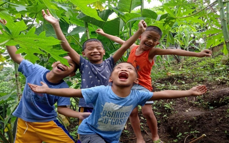 four young boys jumping for joy and smiling