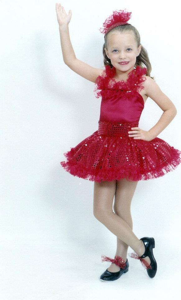 little girl in sparkly red costume and tap shoes