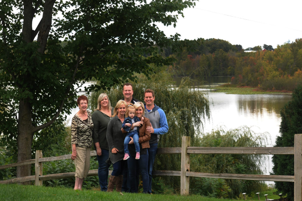family photo in front of fence and lake