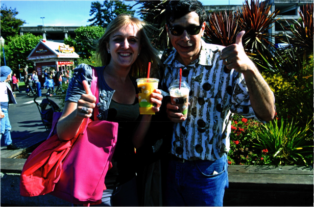 man and woman holding smoothies making the thumbs up sign