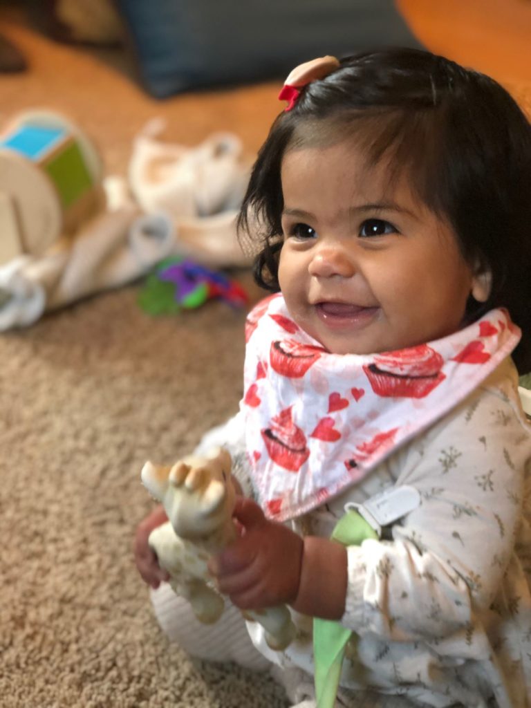smiling baby holding giraffe toy