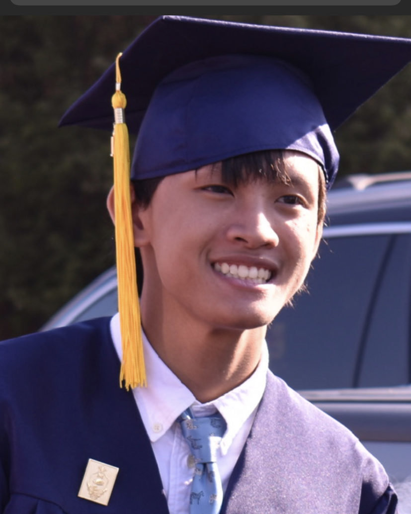 smiling man in navy blue graduation cap and gown