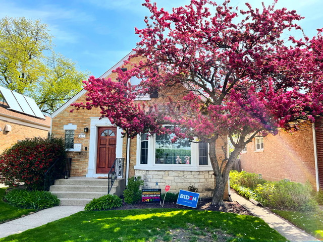 red brick house with blooming cherry blossom tree in front yard