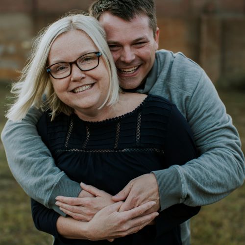laughing man with arms around laughing woman