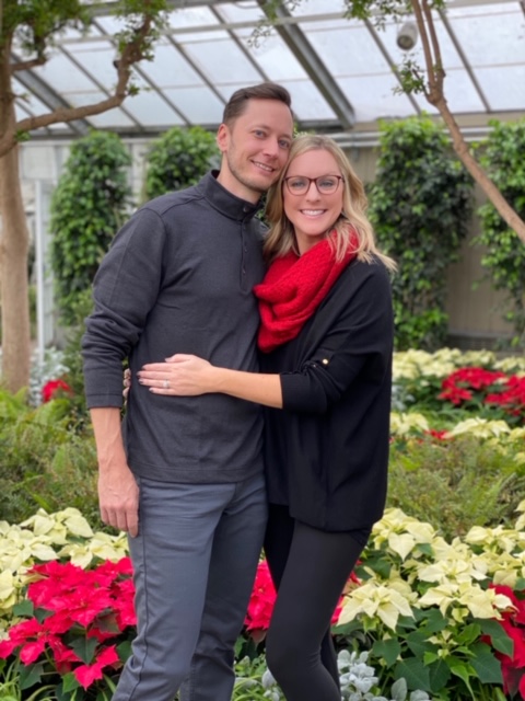 smiling woman in red scarf with her arms around smiling man