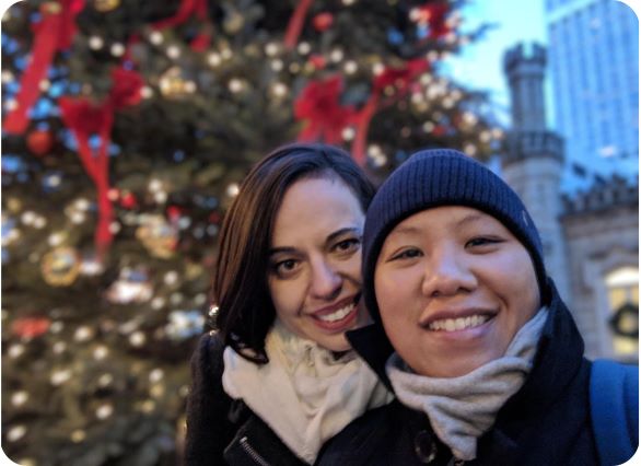 selfie of two women in front of lit christmas tree