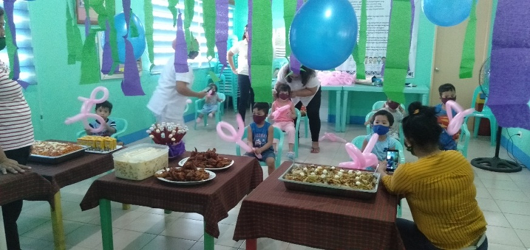 children in care sitting at tables with balloons and special treats