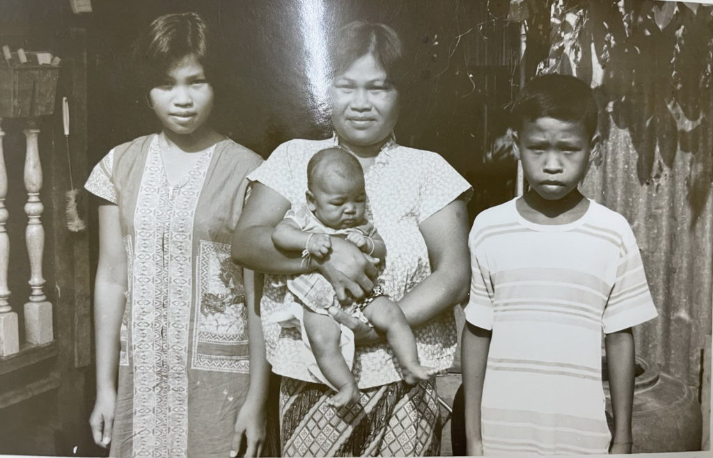 woman holding baby with older girl on the left and older boy on the right