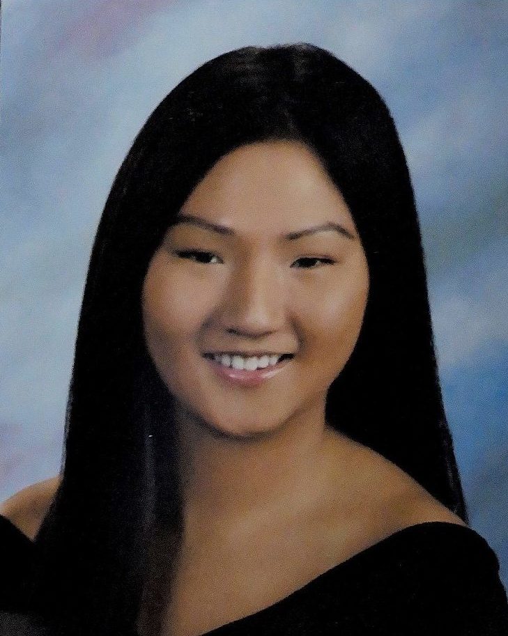 school photo of smiling girl with long hair wearing off the shoulder black top