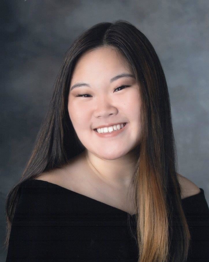 school photo of smiling girl wearing off the shoulder black top