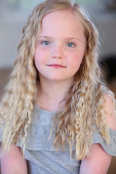 little girl with wavy blonde hair and blue eyes