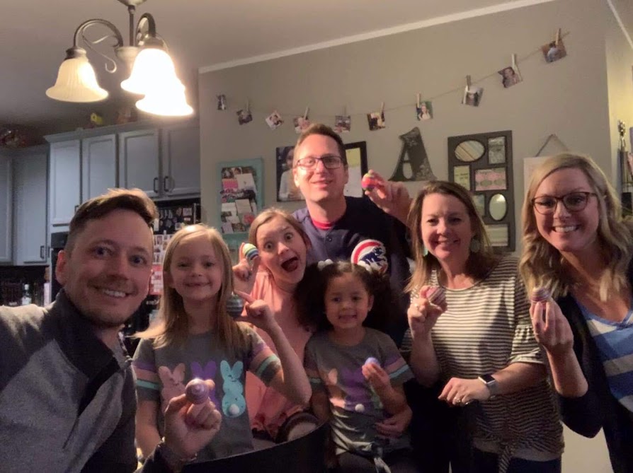 grou pf people holding easter eggs and smiling