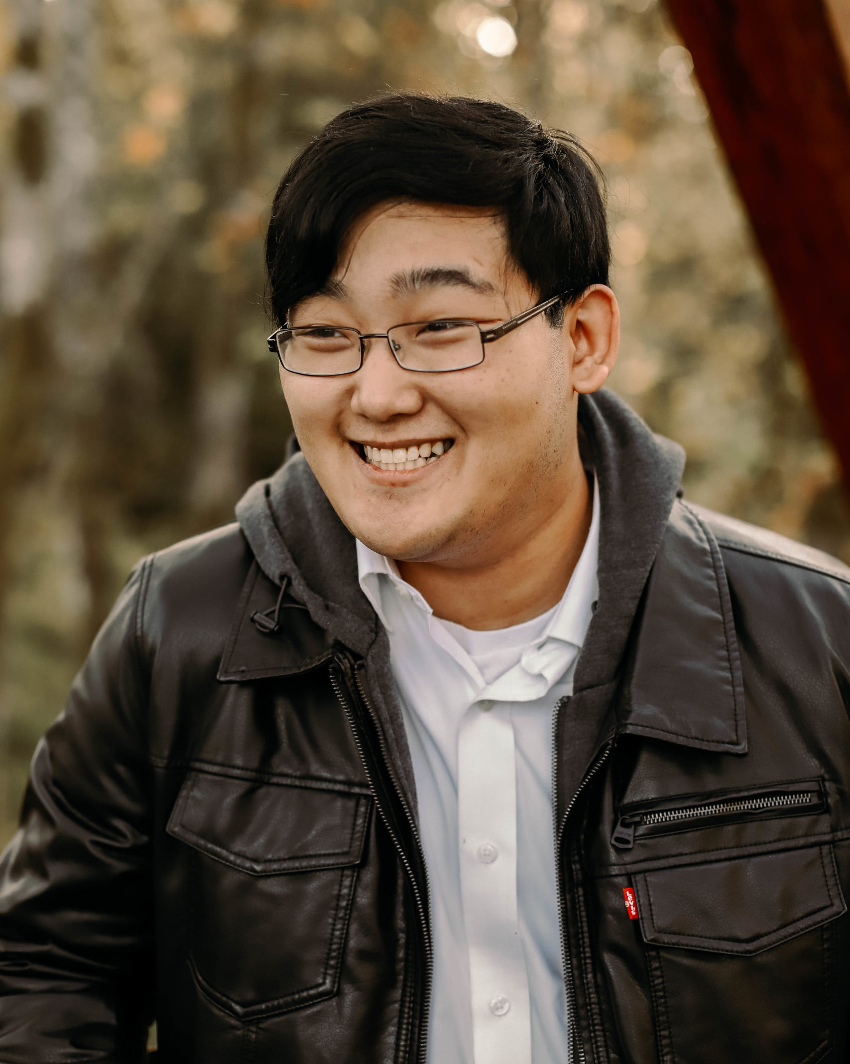 laughing man wearing glasses and leather jacket