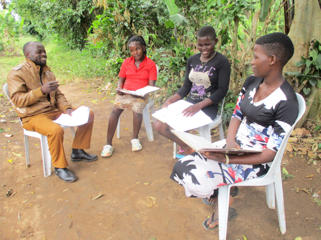 group of four students sitting outside with notebooks