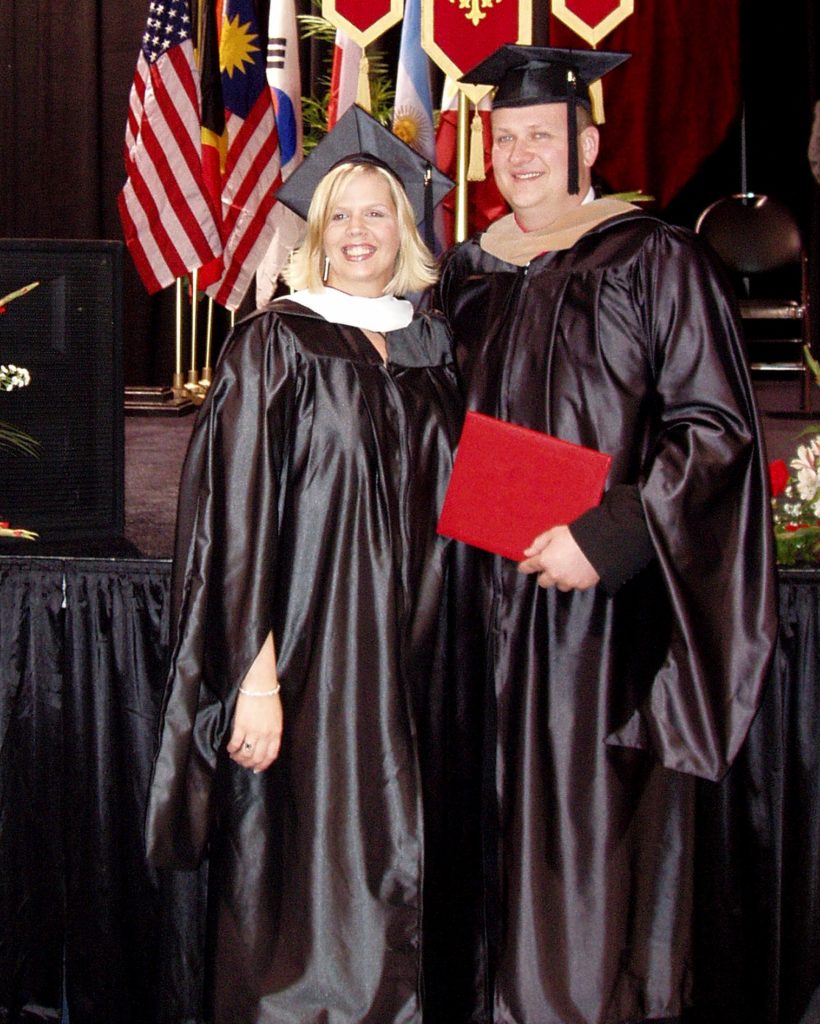 man and woman in black graduation caps and gowns