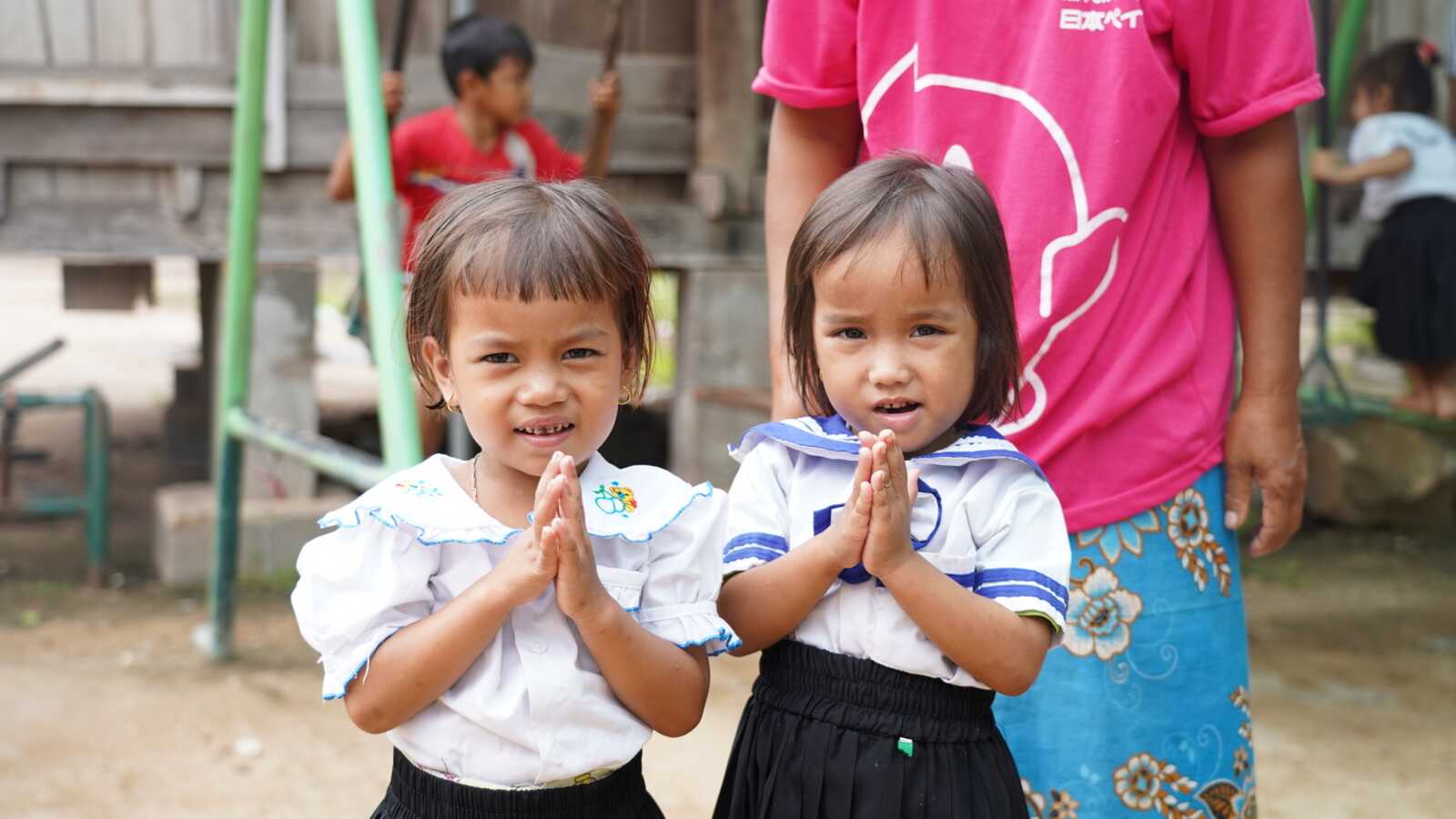 two girls holding prayer hands