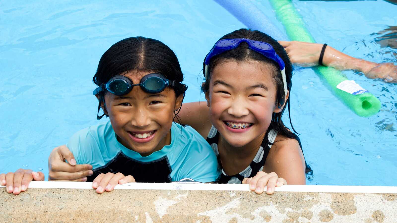 two girls smiling in pool