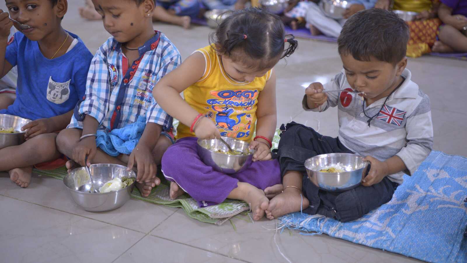 small children eating from bowls in India