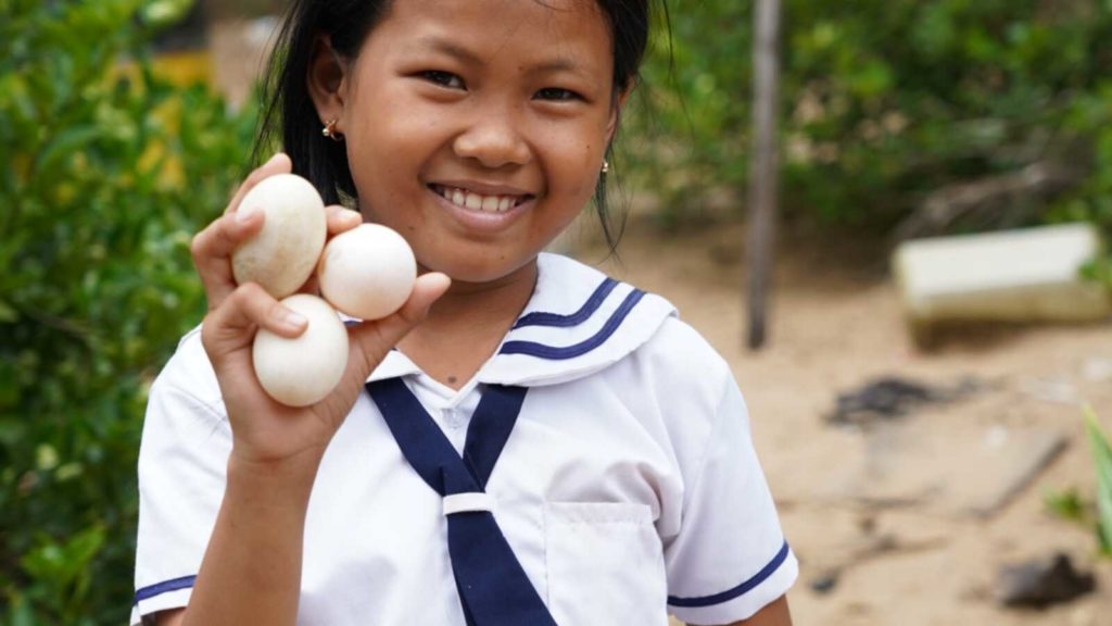 girl holding three eggs in hand