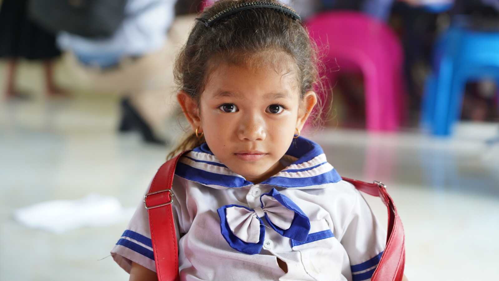 Gril with red backpack in Cambodia