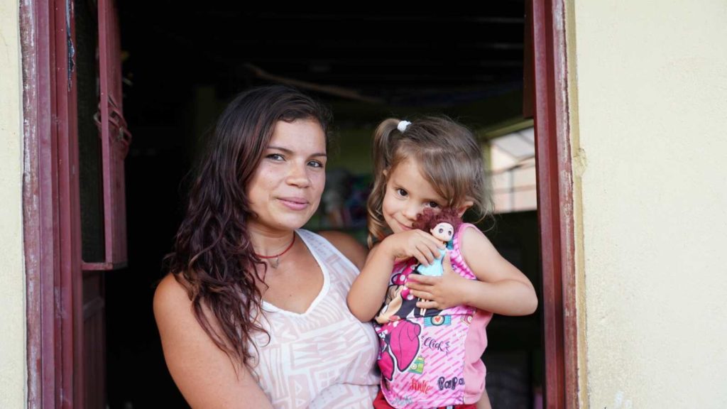 Single mother in Colombia holding her daughter and her doll